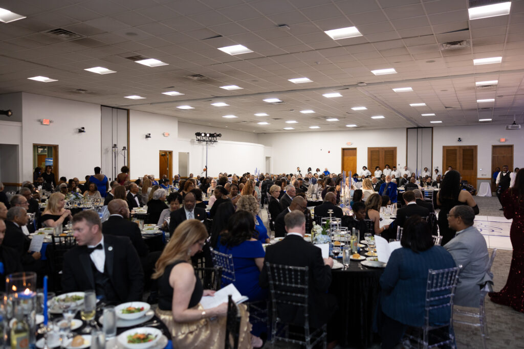 2025 gala with a room full of people in formal attire, sitting at round tables.