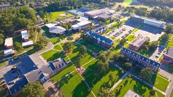 Aerial view of Elizabeth City State University campus showing academic buildings, residence halls, walkways, and green spaces with trees and lawns under bright daylight.