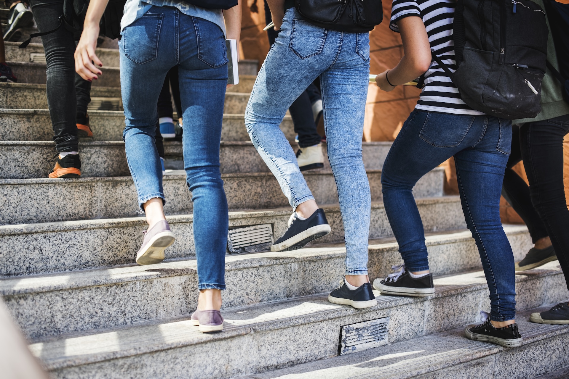 A group of people are ascending a series of concrete steps in an urban setting.